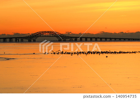 Orange reflection on Frozen Great South Bay at Sunrise With Bridge Near Babylon Orange reflection on Frozen Great South Bay at Sunrise With Bridge Near Babylon 140954735