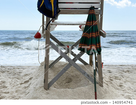 Looking Through a Lifeguard Stand on Sandy Beach Near Ocean Waves in Sunny Weather Looking Through a Lifeguard Stand on Sandy Beach Near Ocean Waves in Sunny Weather 140954741