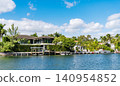 Vacation building in summer. Luxury waterfront house. Hotel building. Residential architecture. Modern building. Residential apartment in waterfront city panorama. Waterfront landscape with house 140954852