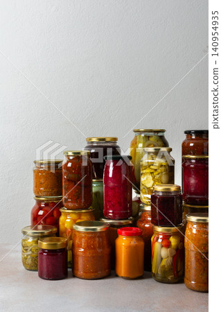 Canning is a common activity in the kitchen as jars filled with vegetables and fruits line the counter. This practice helps in preserving food for winter use and has a long tradition Canning is a common activity in the kitchen as jars filled with vegetables and fruits line the counter. This practice helps in preserving food for winter use and has a long tradition 140954935