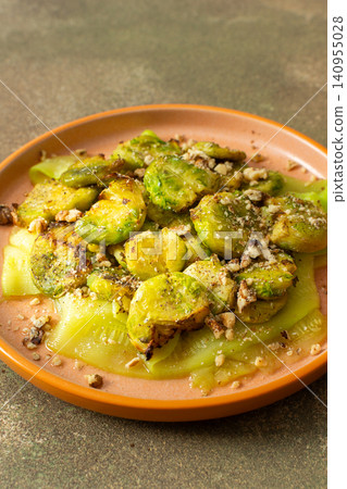 Brussels sprouts and zucchini slices are on a plate and topped with chopped walnuts. This dish can be served for breakfast or lunch. It is a healthy choice for any meal Brussels sprouts and zucchini slices are on a plate and topped with chopped walnuts. This dish can be served for breakfast or lunch. It is a healthy choice for any meal 140955028