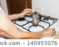 Placing Moka Pot on Gas Stove for Coffee Brewing 140955076