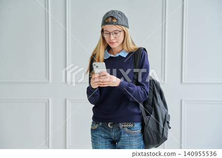 Teenage student girl with backpack using smartphone Teenage student girl with backpack using smartphone 140955536