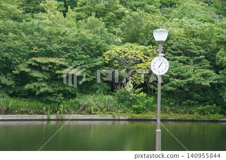 The lush greenery of the former Nakagawa Waterfront Park and the clock standing by the water. The lush greenery of the former Nakagawa Waterfront Park and the clock standing by the water. 140955844
