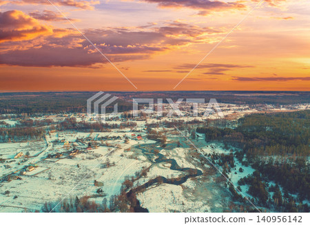 Aerial view of rural landscape at sunset. Top view of a narrow winding river and countryside in a snowy winter; Aerial view of rural landscape at sunset. Top view of a narrow winding river and countryside in a snowy winter; 140956142
