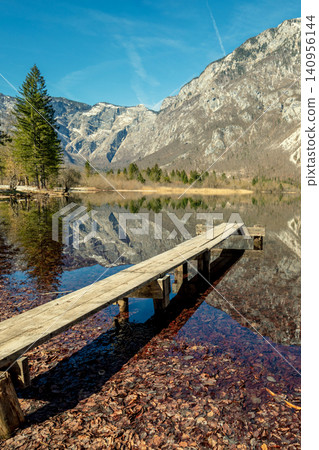 Mountain lake with reflection. Wooden boat pier on the lake Mountain lake with reflection. Wooden boat pier on the lake 140956144