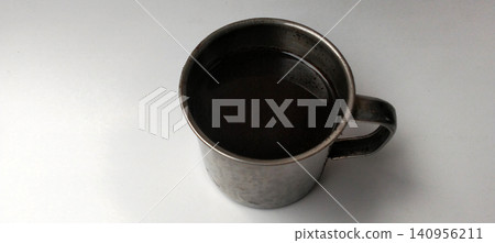 Stainless steel mug containing black coffee against a white background. Stainless steel mug containing black coffee against a white background. 140956211