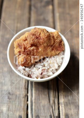 Large, crispy and juicy fried chicken thighs served on top of rice. Large, crispy and juicy fried chicken thighs served on top of rice. 140956247