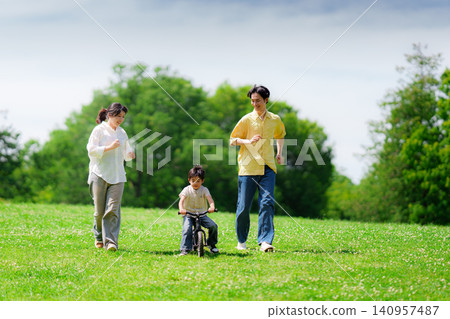 A boy practicing riding a bicycle in the park A boy practicing riding a bicycle in the park 140957487