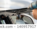 A car wrapping specialist applies a polyurethane film to the car. Detailer PPF 140957917