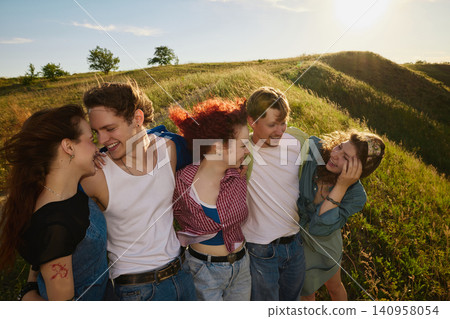 Group of friends hugging and laughing on sunny countryside hill. Group of friends hugging and laughing on sunny countryside hill. 140958054
