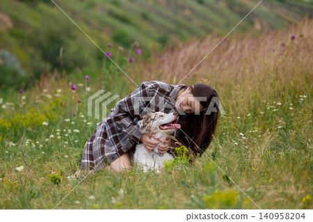 Woman hugging dog in peaceful wildflower meadow. Woman hugging dog in peaceful wildflower meadow. 140958204