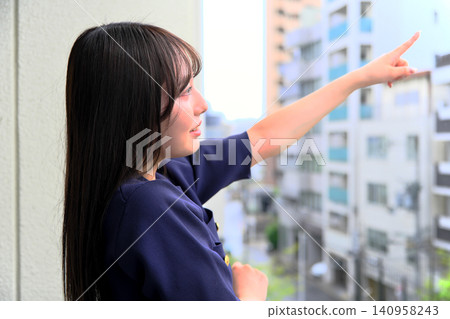 一位微笑的女子高興地指著陽台。 140958243