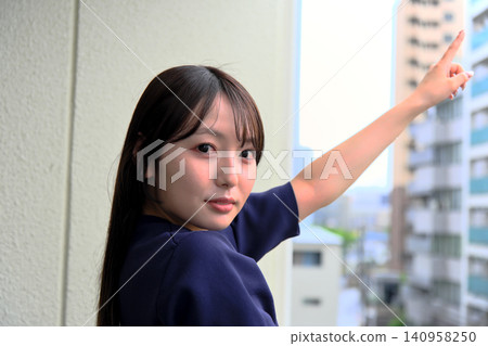 一位微笑的女子高興地指著陽台。 一位微笑的女子高興地指著陽台。 140958250