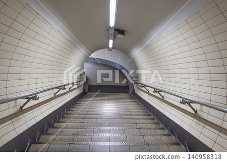 Empty tiled pedestrian tunnel with stairs in a subway station Empty tiled pedestrian tunnel with stairs in a subway station 140958318