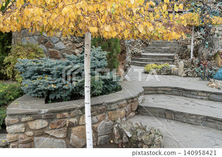 Pathway through a garden with autumn leaves Pathway through a garden with autumn leaves 140958421