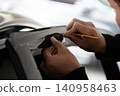 A car wrapping specialist applies a polyurethane film to the car. Detailer PPF 140958463