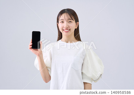 Japanese woman showing her smartphone screen Japanese woman showing her smartphone screen 140958586