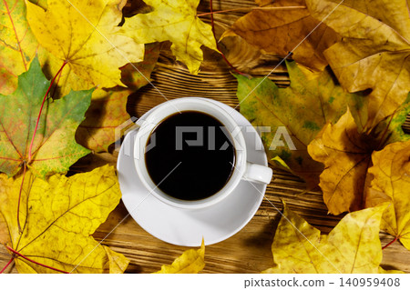Cup of coffee and autumn maple leaves on wooden table. Top view. Autumn concept Cup of coffee and autumn maple leaves on wooden table. Top view. Autumn concept 140959408