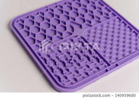 Slow feeding licking mat for dogs and cats used in home setting during play Slow feeding licking mat for dogs and cats used in home setting during play 140959680