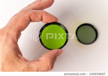 Holding a green filter for vintage movie cameras in hand Holding a green filter for vintage movie cameras in hand 140959697