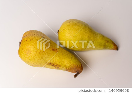 Two yellow pears on a plain background sitting together Two yellow pears on a plain background sitting together 140959698
