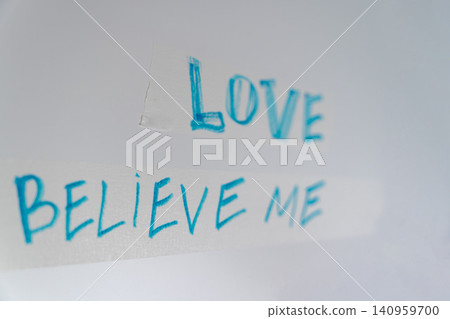 Message written on a wall that says Love Believe Me in bright blue color Message written on a wall that says Love Believe Me in bright blue color 140959700