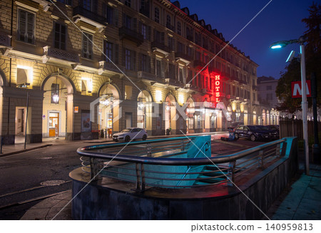 Turin, piedmont, italy. November 20, 2024. Turin city street scene at night featuring the illuminated hotel roma sign and a metro entrance in the foreground Turin, piedmont, italy. November 20, 2024. Turin city street scene at night featuring the illuminated hotel roma sign and a metro entrance in the foreground 140959813
