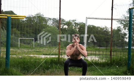 Male shirtless athlete doing squats at sports ground. Young sportsman working at summer nature. Strong sporty man exercising outdoor. Concept of active and sportive lifestyle. Slow motion Male shirtless athlete doing squats at sports ground. Young sportsman working at summer nature. Strong sporty man exercising outdoor. Concept of active and sportive lifestyle. Slow motion 140959849