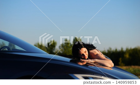 Beautiful smiling girl bought new electrical vehicle and hugging hood auto. Happy young woman enjoying modern electric automobile. Concept of buy or rent car. Slow motion Beautiful smiling girl bought new electrical vehicle and hugging hood auto. Happy young woman enjoying modern electric automobile. Concept of buy or rent car. Slow motion 140959853