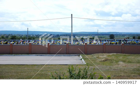 View from window of moving automobile on large military cemetery in Kharkiv with countless graves marked by Ukrainian flags. The site commemorates soldiers who died during russian invasion in Ukraine View from window of moving automobile on large military cemetery in Kharkiv with countless graves marked by Ukrainian flags. The site commemorates soldiers who died during russian invasion in Ukraine 140959917