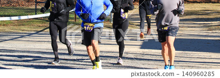 Runners Participate in a Race on a Sunny Day in a Park Setting during Winter Runners Participate in a Race on a Sunny Day in a Park Setting during Winter 140960285