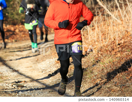 Runners Compete in a Trail Run on a Cold Day in the Forest 140960314