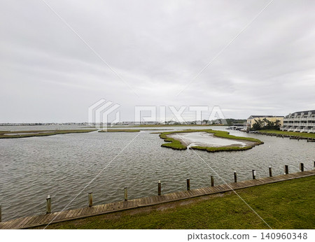 The Water in Fenwick Island Delaware With Grass and Buildings Nearby The Water in Fenwick Island Delaware With Grass and Buildings Nearby 140960348