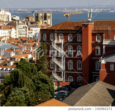 View of Lisbon Rooftops and Buildings With a Circular Staircase and Backdrop of the Sea View of Lisbon Rooftops and Buildings With a Circular Staircase and Backdrop of the Sea 140960372