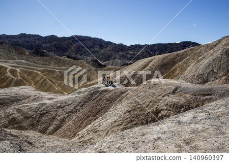 Tourist Observing the Beauty of Zabriiskie Points Landscapes in the Badlands of Death Valley Tourist Observing the Beauty of Zabriiskie Points Landscapes in the Badlands of Death Valley 140960397