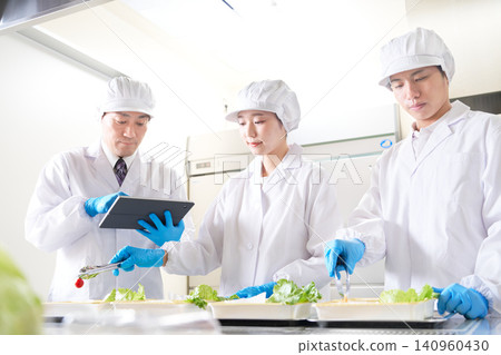 廚師們一邊擺盤一邊檢查工作細節。 廚師們一邊擺盤一邊檢查工作細節。 140960430