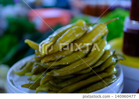 long pickled pepper, pickled chili pepper. Green chili achar in a small bowl. Tasty homemade food and cooking concept. long pickled pepper, pickled chili pepper. Green chili achar in a small bowl. Tasty homemade food and cooking concept. 140960477