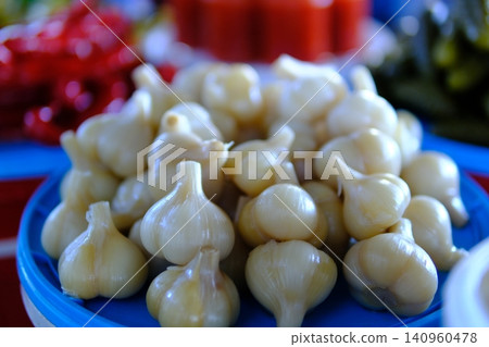 pickled garlic. Pickled garlic in the glass jar on the rustic wooden background.Homemade fermented product. pickled garlic. Pickled garlic in the glass jar on the rustic wooden background.Homemade fermented product. 140960478
