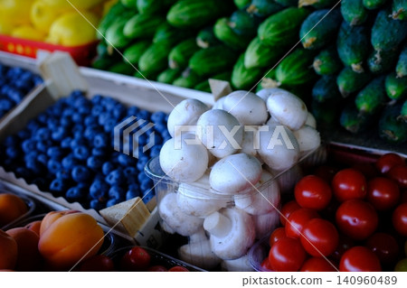 champignons on the market for sale blueberries cucumbers tomatoes 140960489