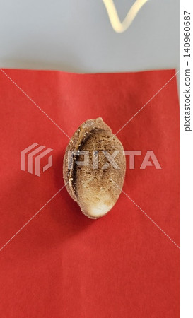 Traditional baked walnut shaped cookies with sweet condensed milk filling placed on red napkin in cozy homemade dessert and bakery atmosphere Traditional baked walnut shaped cookies with sweet condensed milk filling placed on red napkin in cozy homemade dessert and bakery atmosphere 140960687