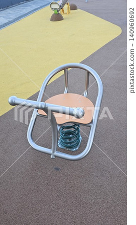 Colorful empty playground with spring riders and seesaws on rubber flooring Colorful empty playground with spring riders and seesaws on rubber flooring 140960692