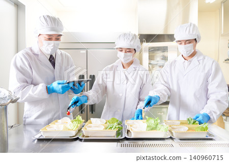 廚師們一邊擺盤一邊檢查工作細節。 廚師們一邊擺盤一邊檢查工作細節。 140960715