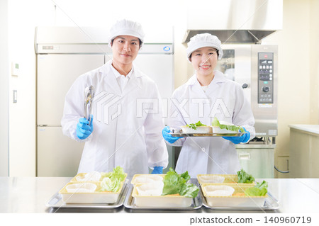 Two young male and female staff members smile while looking directly at the camera. Two young male and female staff members smile while looking directly at the camera. 140960719