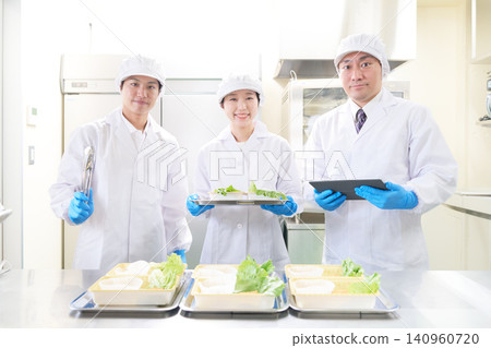 一家食品工廠的三名男女員工面帶微笑,直視鏡頭。 一家食品工廠的三名男女員工面帶微笑,直視鏡頭。 140960720