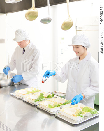 Cooking staff in white coats divide the work amongst themselves. Cooking staff in white coats divide the work amongst themselves. 140960734