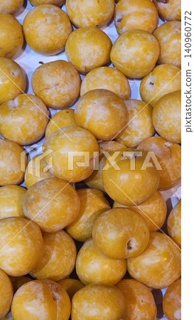 Ripe yellow cherry plums on white tiled table, closeup Ripe yellow cherry plums on white tiled table, closeup 140960772