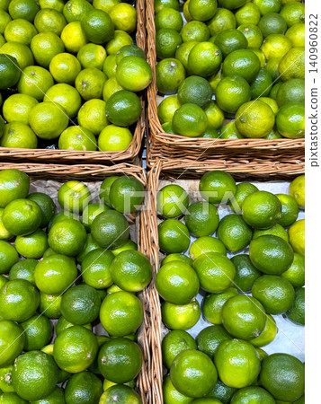 Limes baskets fresh, vibrant green limes heaped in woven basket. The textured skin and rich color emphasize their freshness and quality. Limes baskets fresh, vibrant green limes heaped in woven basket. The textured skin and rich color emphasize their freshness and quality. 140960822