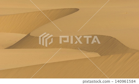 A minimalist perspective on the vast Viana desert landscape in Boa Vista, Cape Verde. The scene is a striking abstract composition formed by the golden sand dunes. A minimalist perspective on the vast Viana desert landscape in Boa Vista, Cape Verde. The scene is a striking abstract composition formed by the golden sand dunes. 140961584