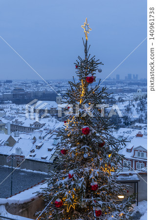 Christmas tree glowing above snowy Prague rooftops 140961738
